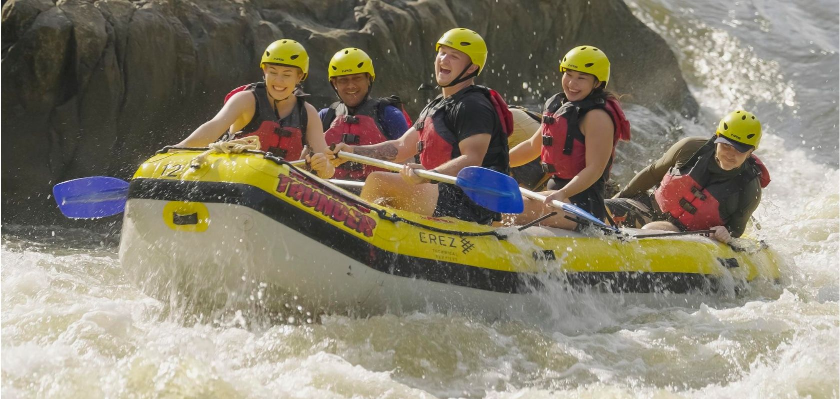 A Group Of People Riding On A Raft In The Water at Rapids Adventures