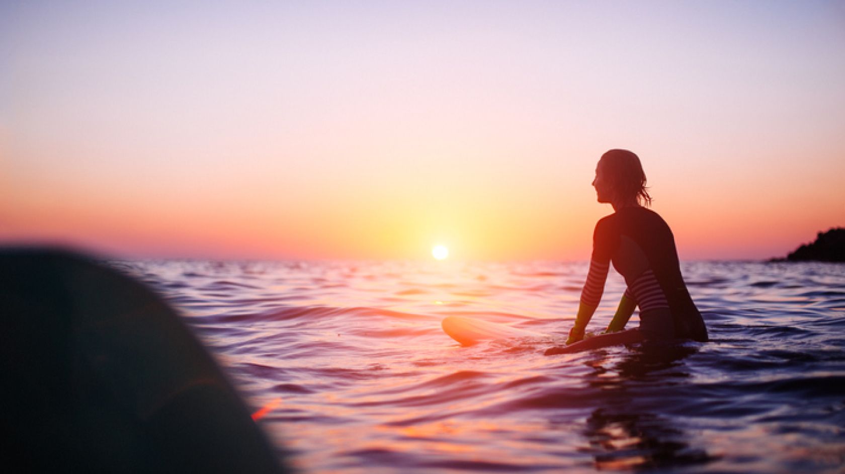 A Person With A Sunset In The Ocean