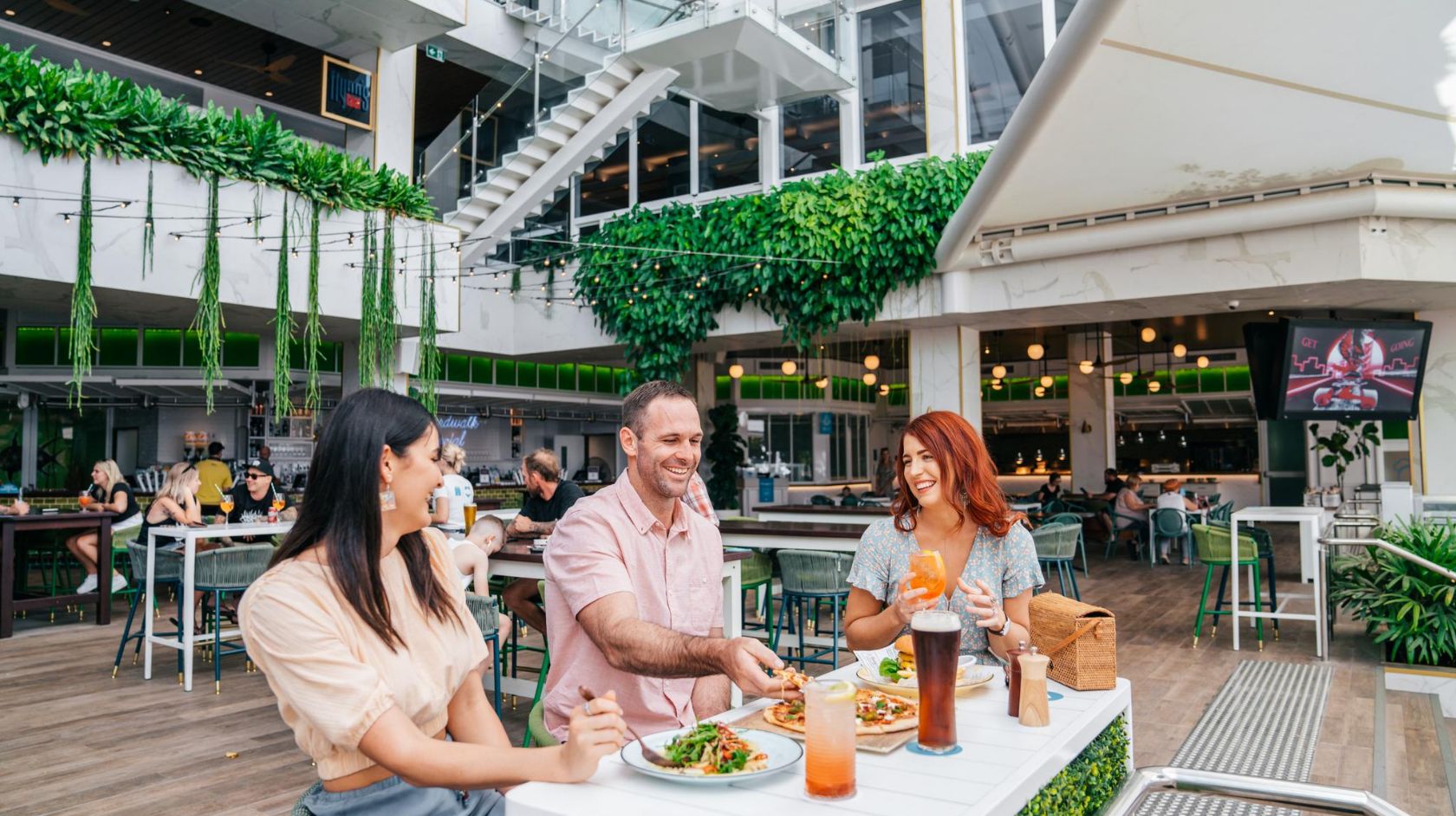 A Group Of People Sitting At A Table Eating Food