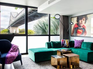 A Living Room With A Green Couch And A Large Window