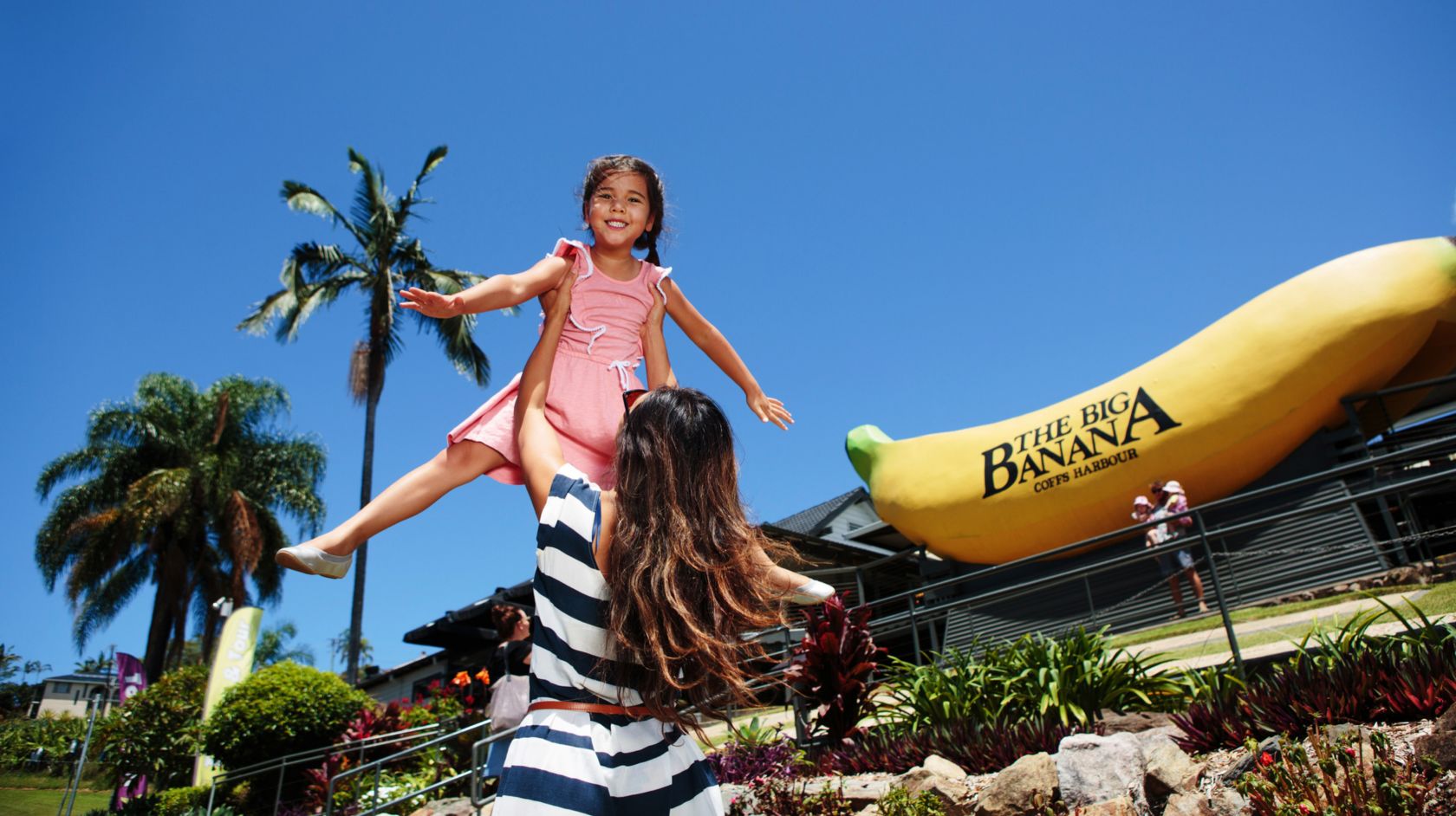 A Person Holding A Girl On at Big Banana