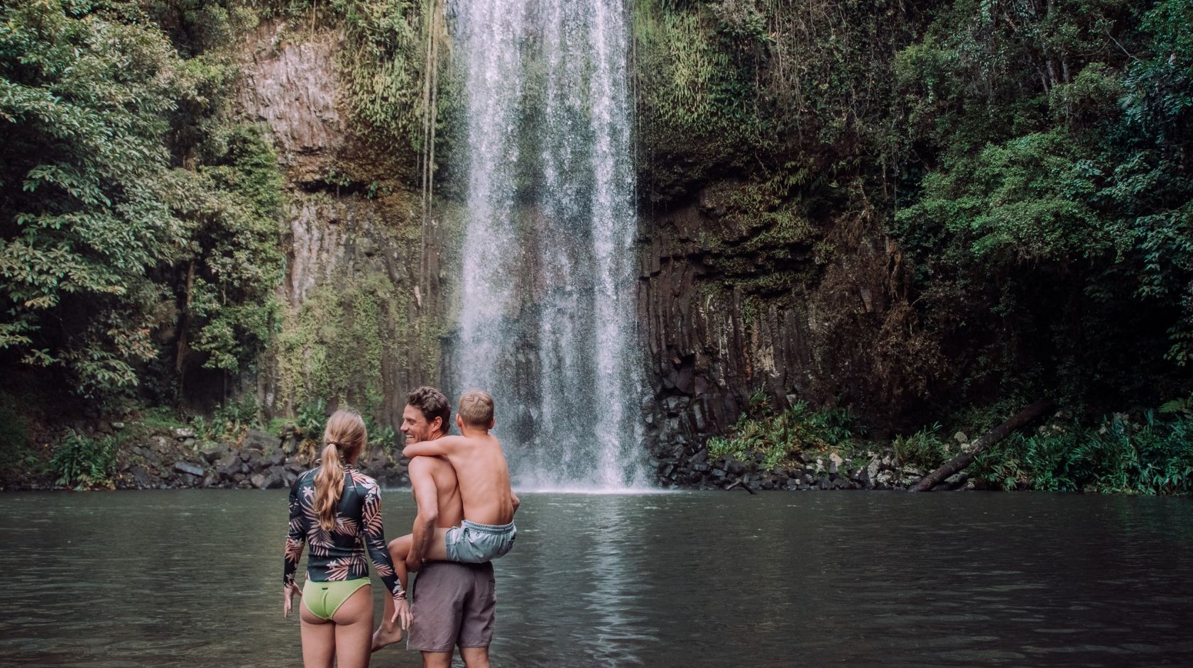 A Group Of People Standing In Front Of Millaa Millaa Falls